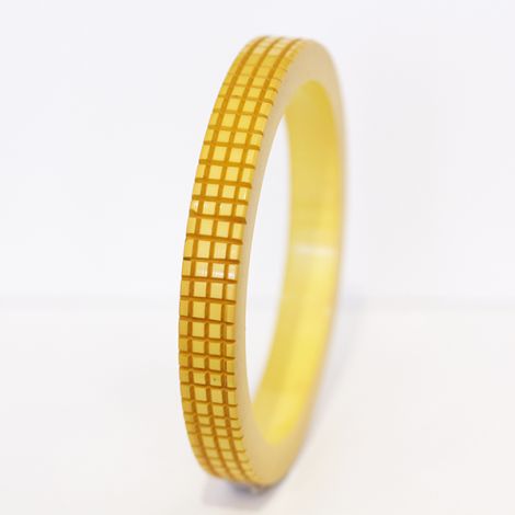 Deeply carved Art Deco era butterscotch Bakelite bangle with an abstract “X” pattern