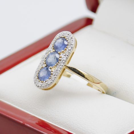 sapphire diamond pill ring, 9ct yellow gold, pill-shaped design, natural blue sapphires, sparkling diamonds, elegant jewelry, fine craftsmanship, polished finish, extended shoulders, open back.