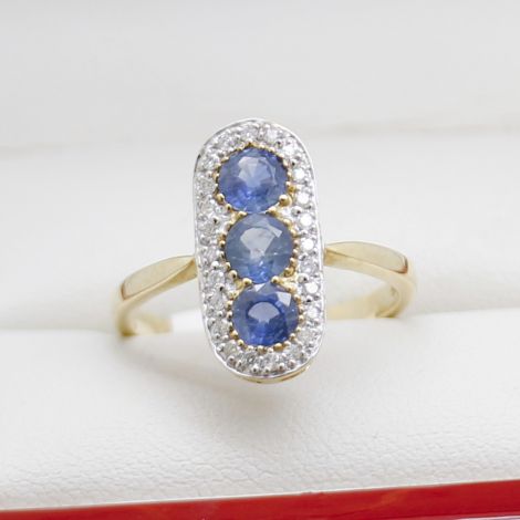 sapphire diamond pill ring, 9ct yellow gold, pill-shaped design, natural blue sapphires, sparkling diamonds, elegant jewelry, fine craftsmanship, polished finish, extended shoulders, open back.